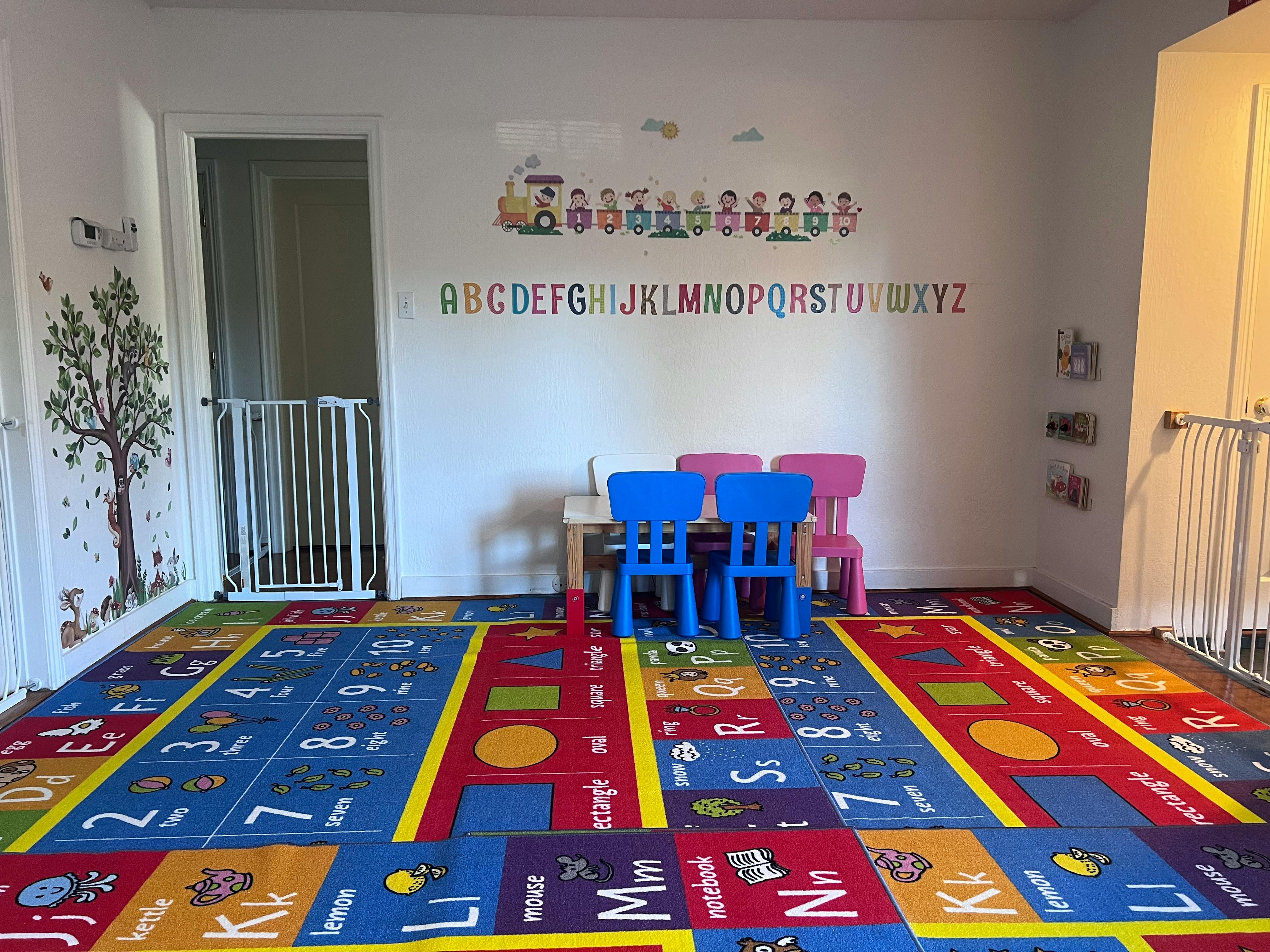 Playroom with alphabet rug, small table, and chairs