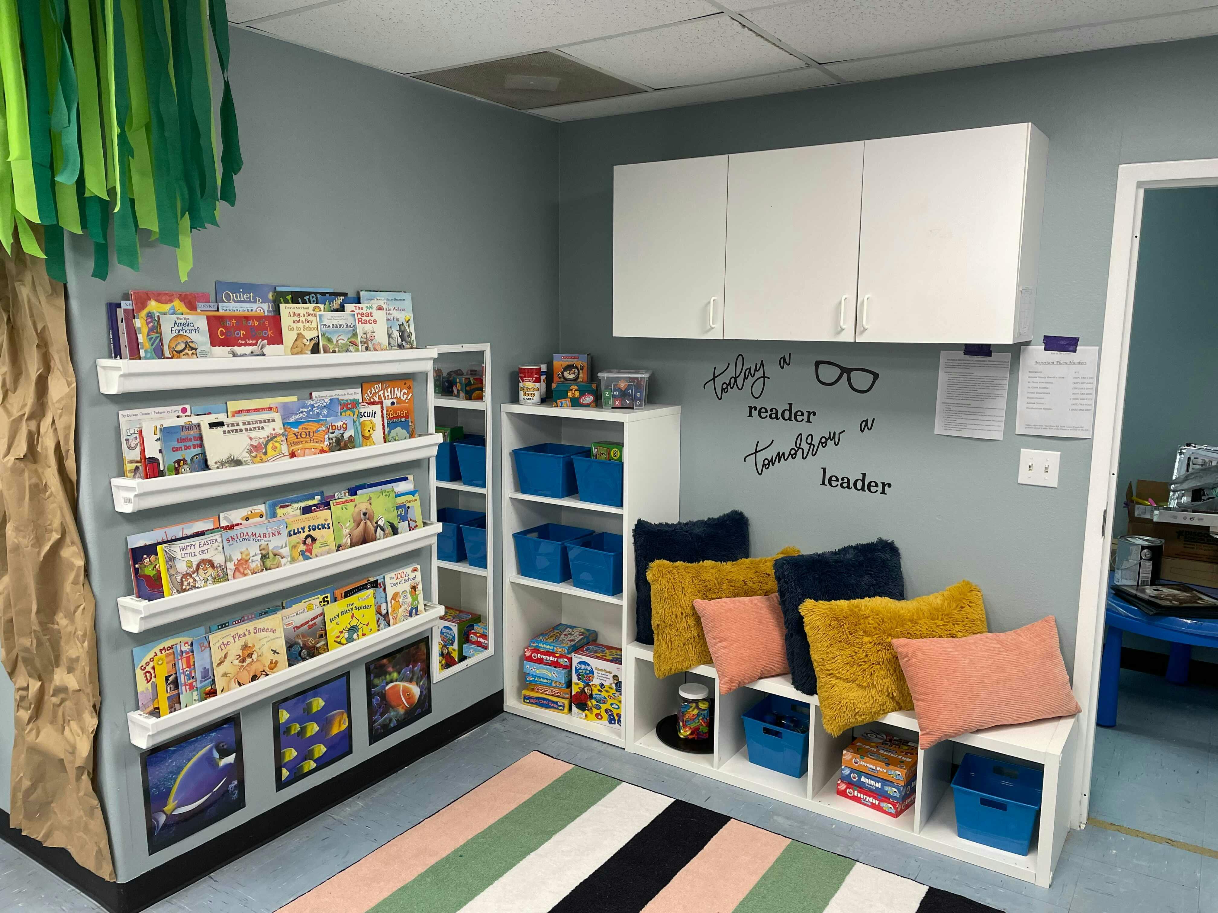 Children's reading nook with bookshelves, pillows, and a striped rug