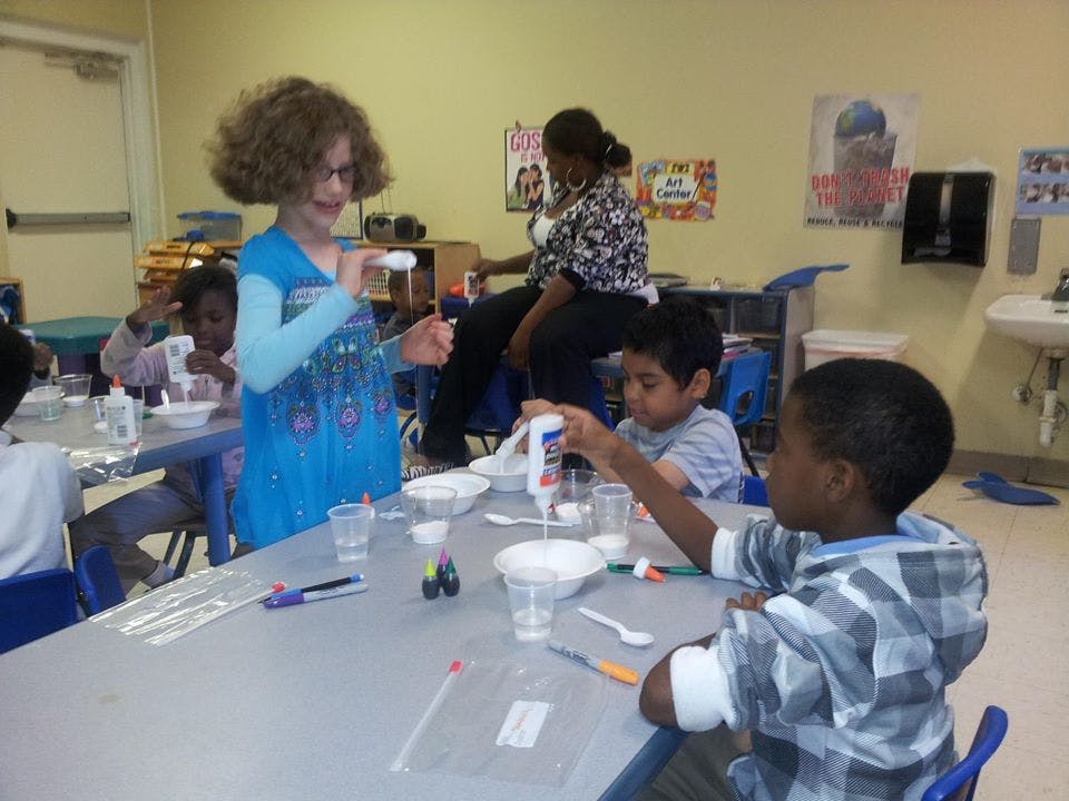 Children at a table doing an activity with cups and bottles