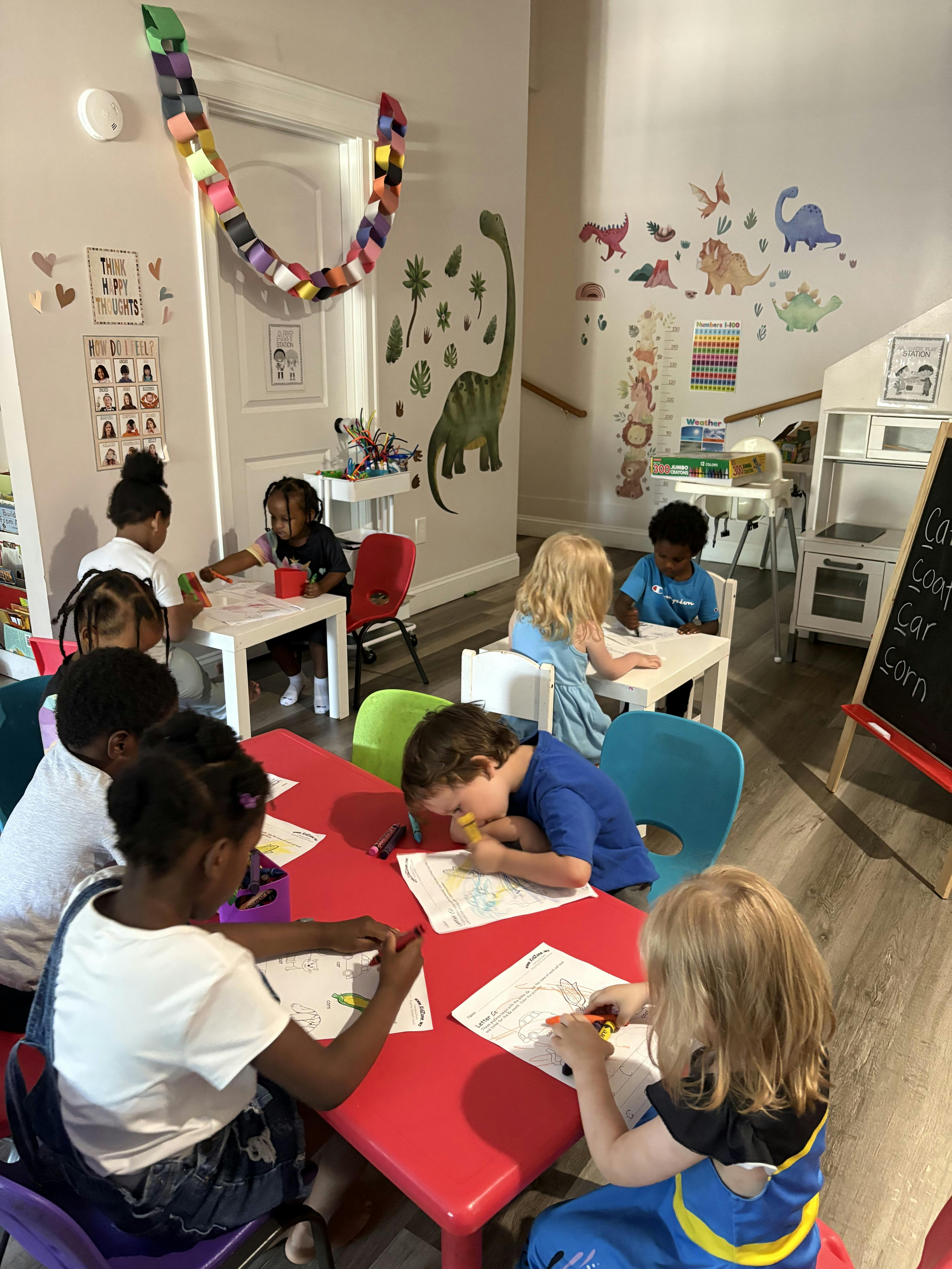 Children coloring at small tables in a classroom