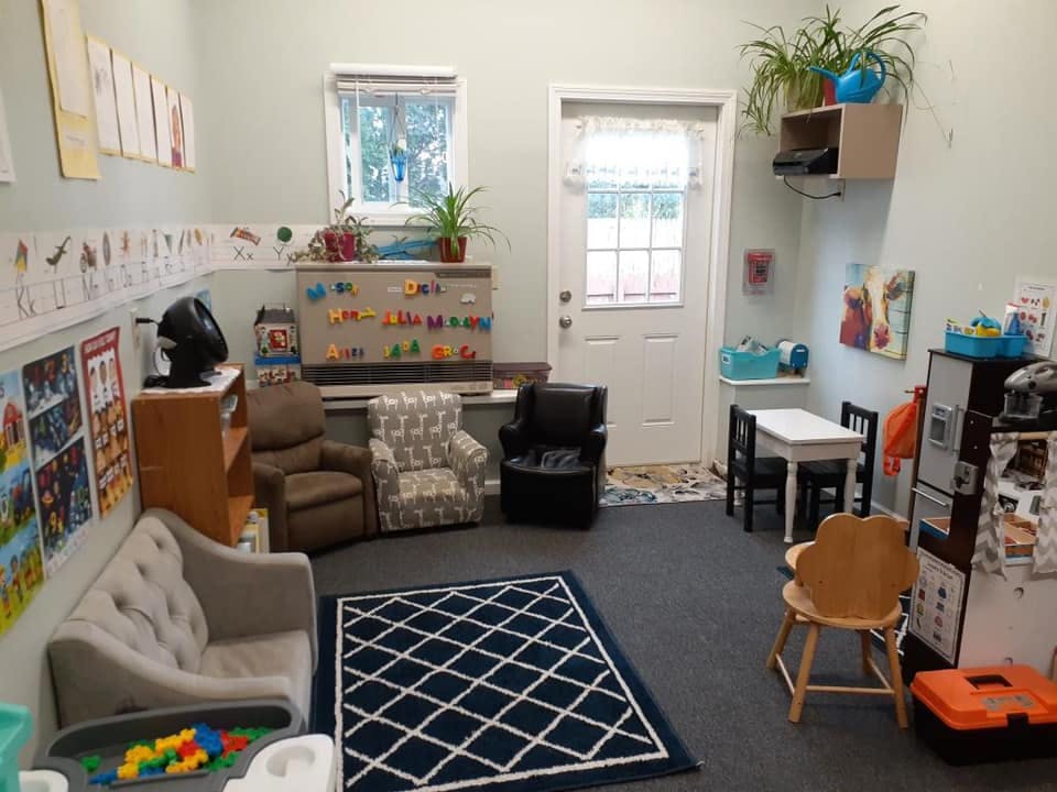 Child's playroom with small chairs, tables, and a rug