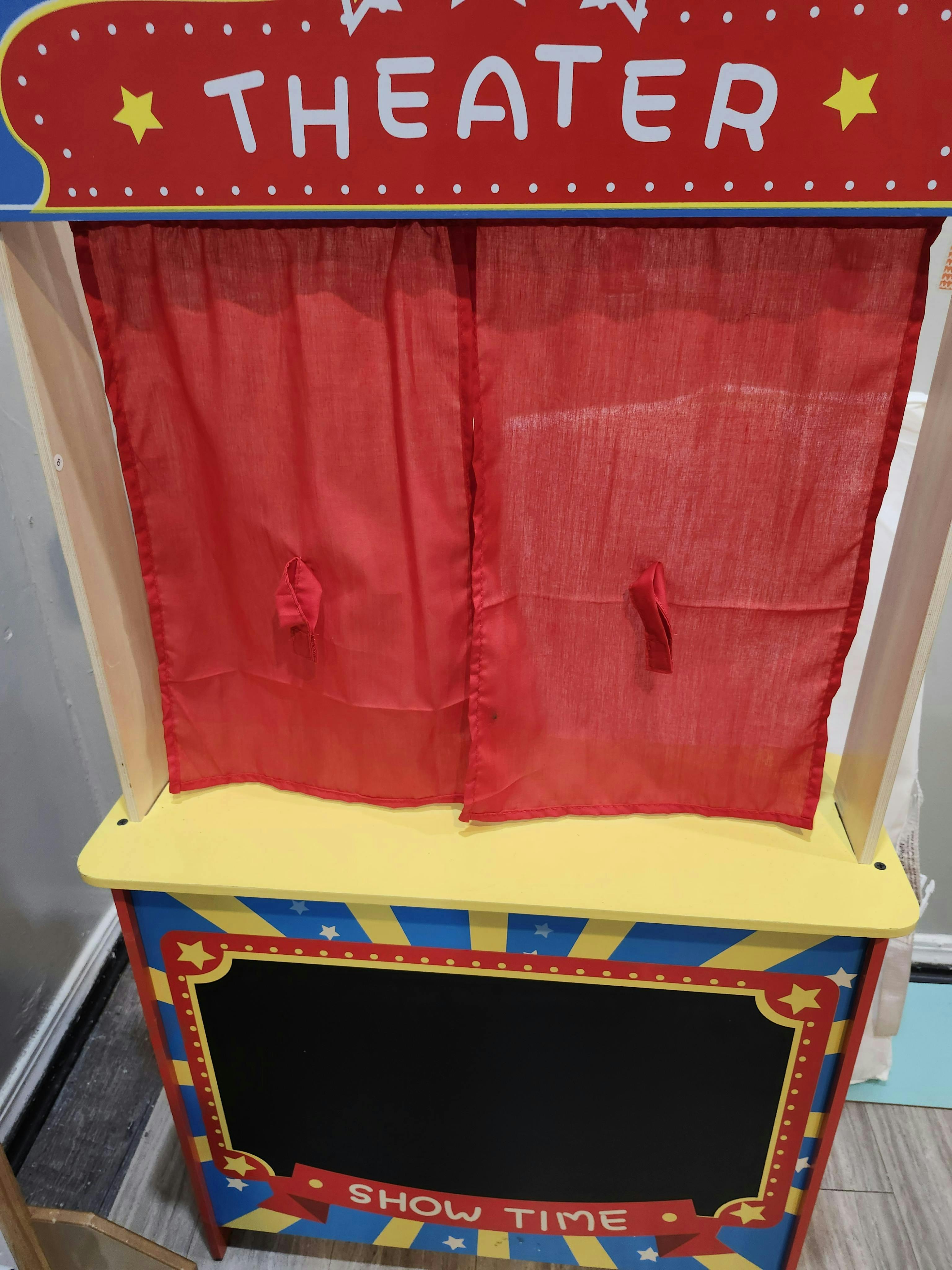 Toy theater with red curtains and a chalkboard sign that says "SHOW TIME"
