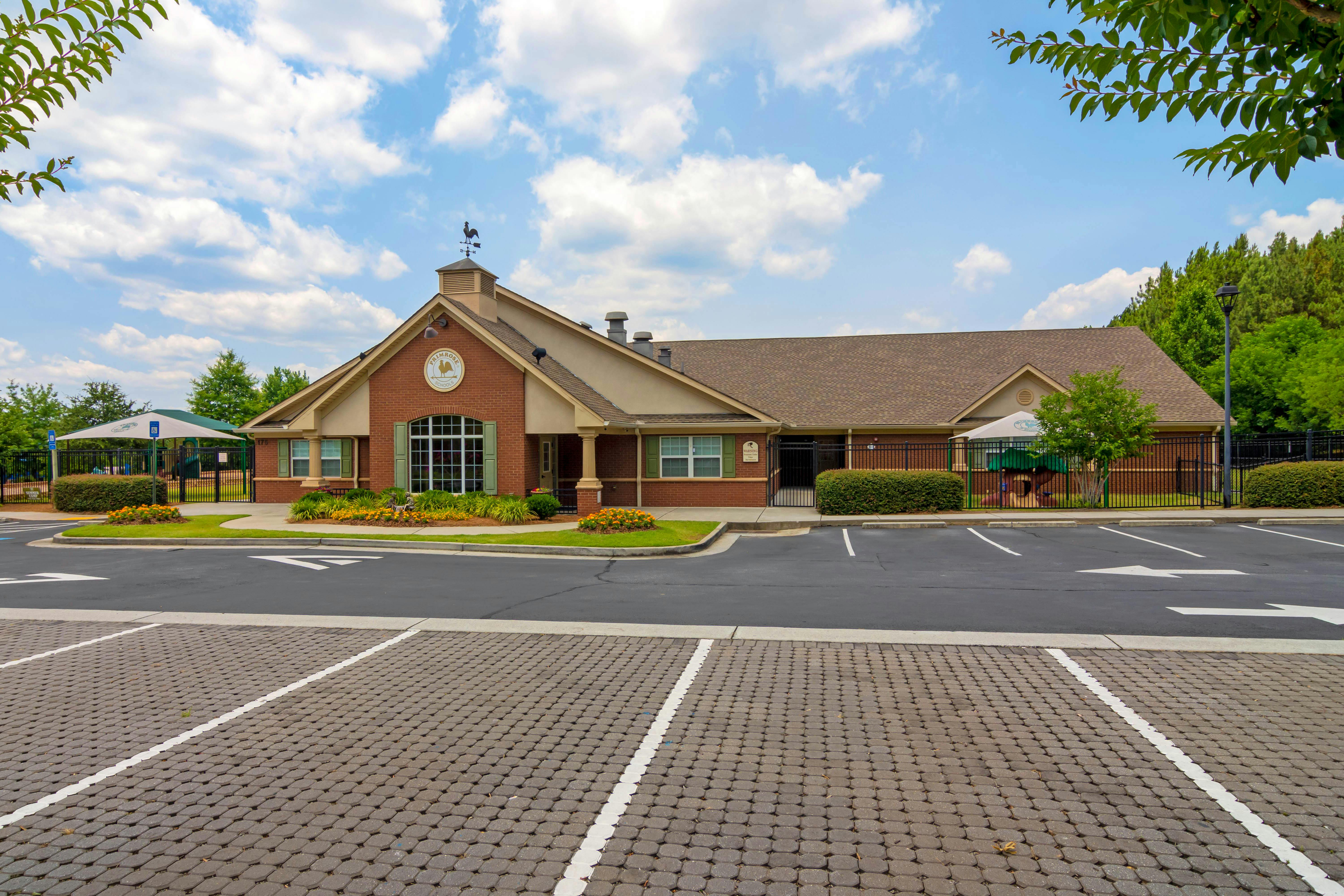 A Primrose Schools building with a playground and parking lot