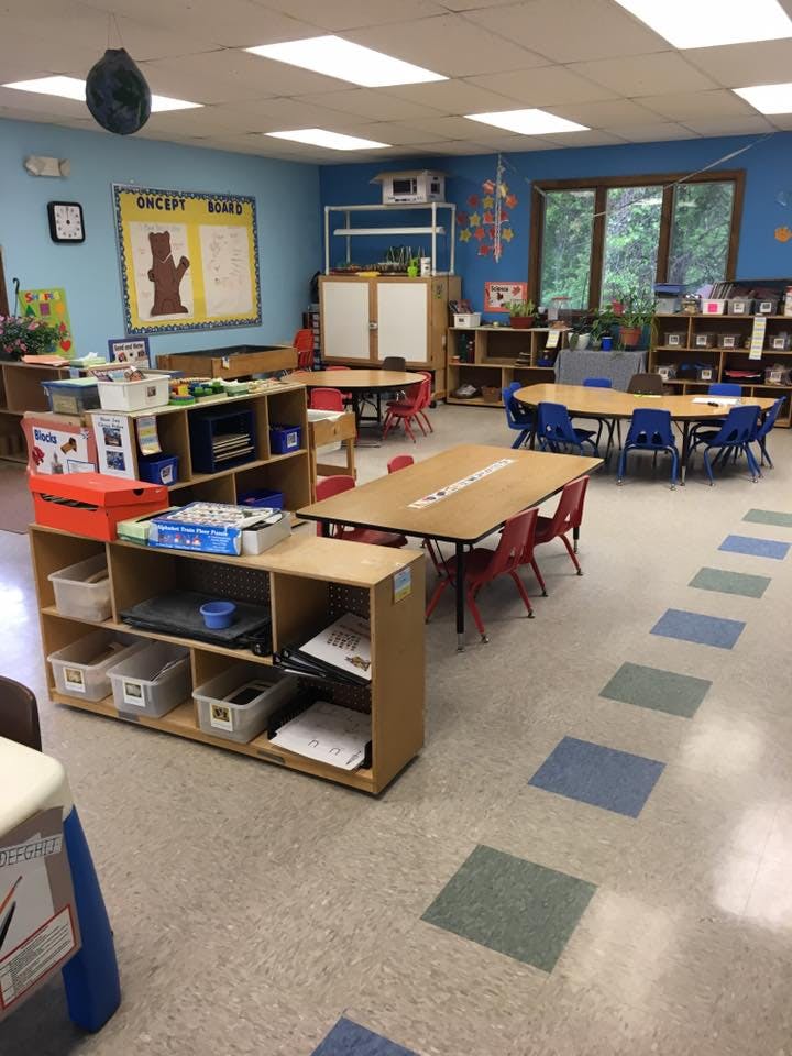 Classroom with tables, chairs, and storage shelves