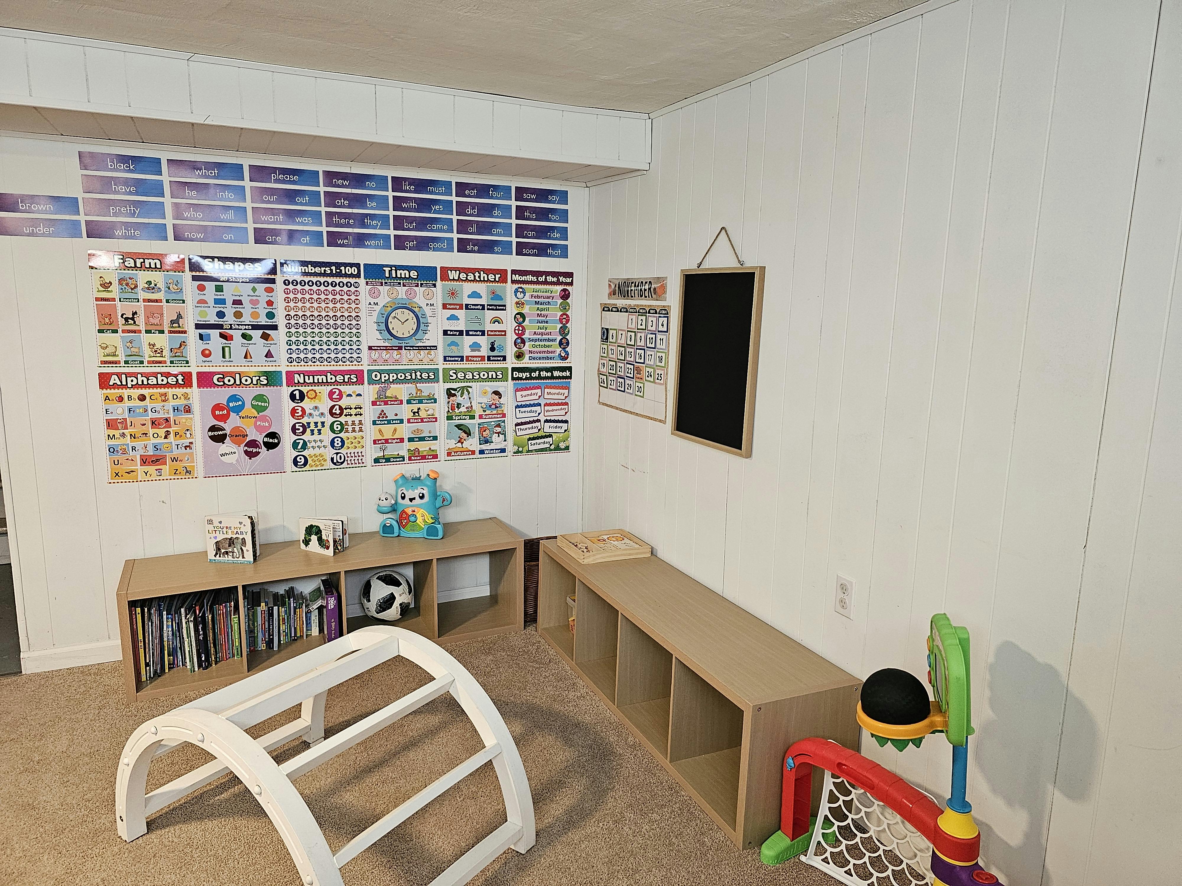 Playroom with educational posters, storage shelves, and children's toys