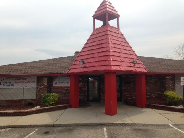 Brick building with red columns and a red peaked roof