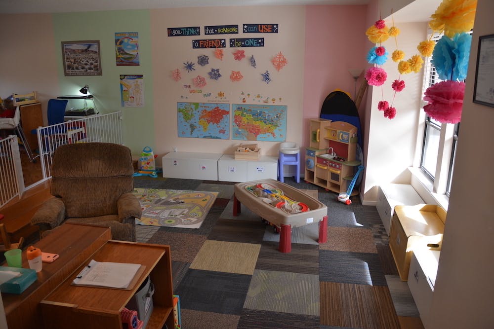 Playroom with a recliner, play kitchen, and sand table