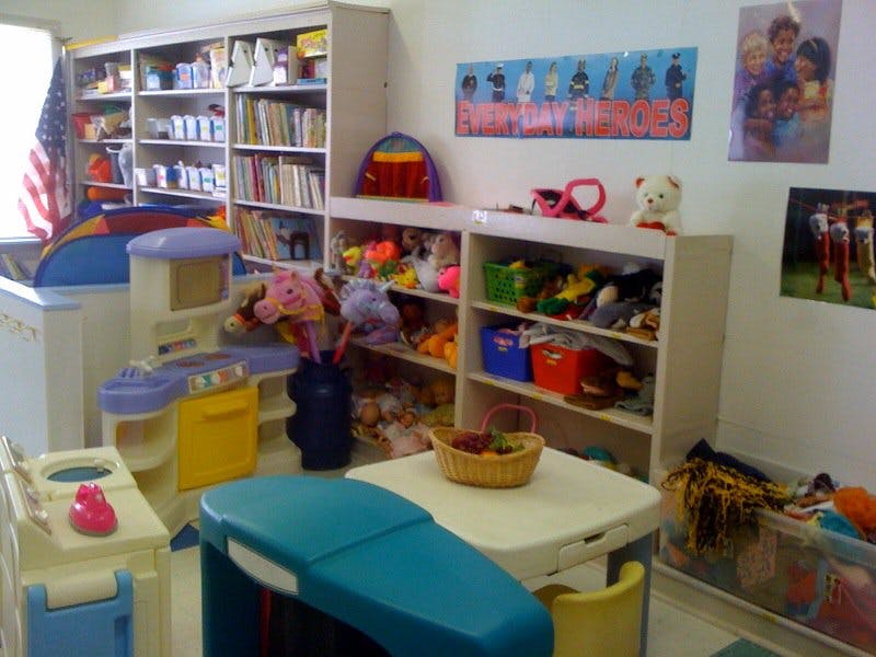 Playroom with shelves of toys and books, small table and chairs