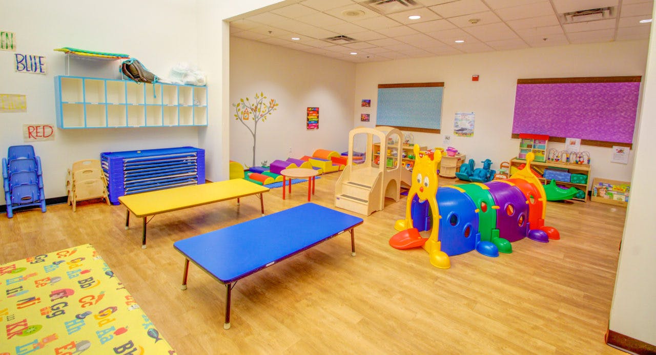 Playroom with colorful tables, chairs, and play equipment