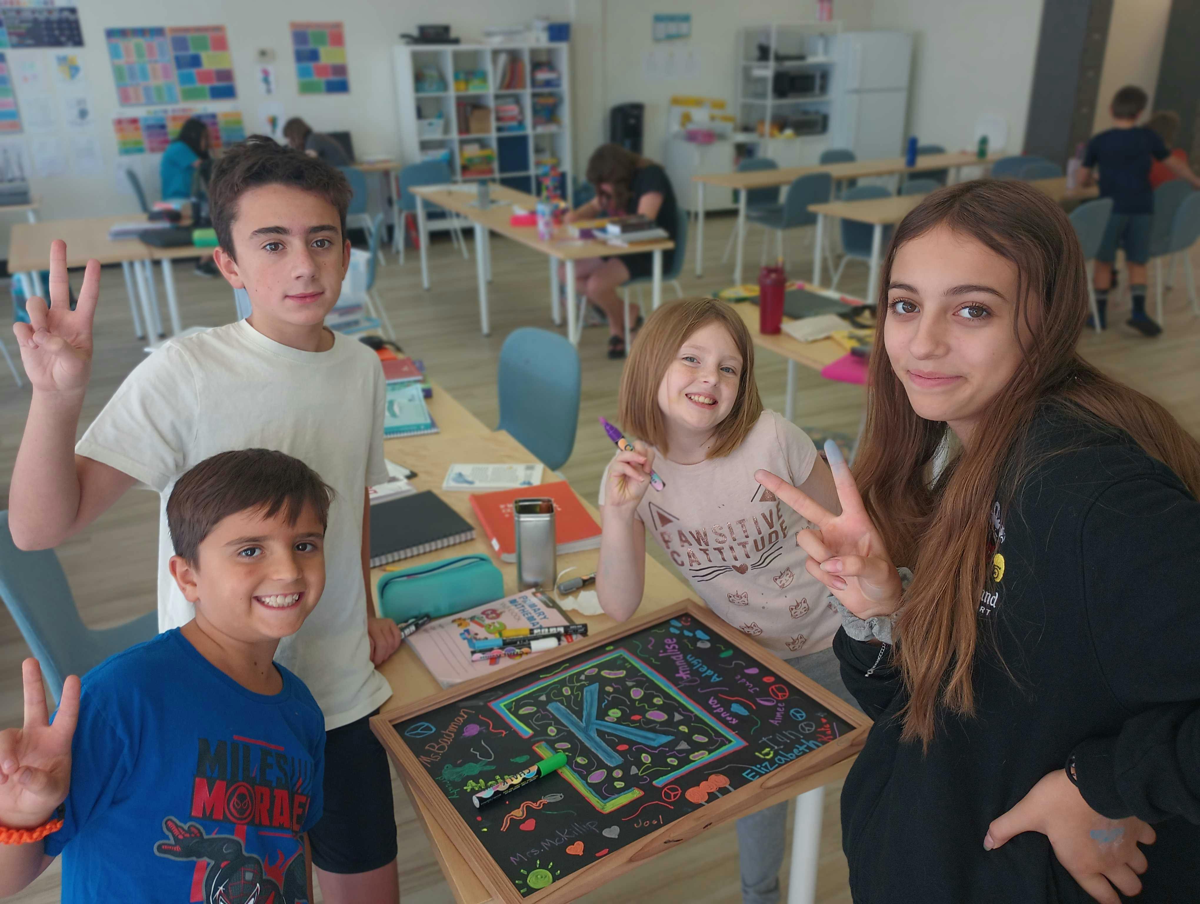 Four children posing in a classroom