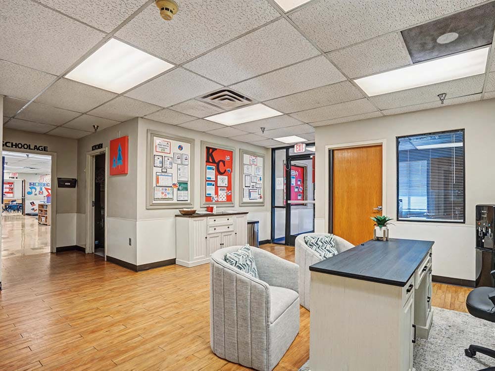 Lobby area with a desk, two chairs, and a hallway leading to a room marked "Schoolage"