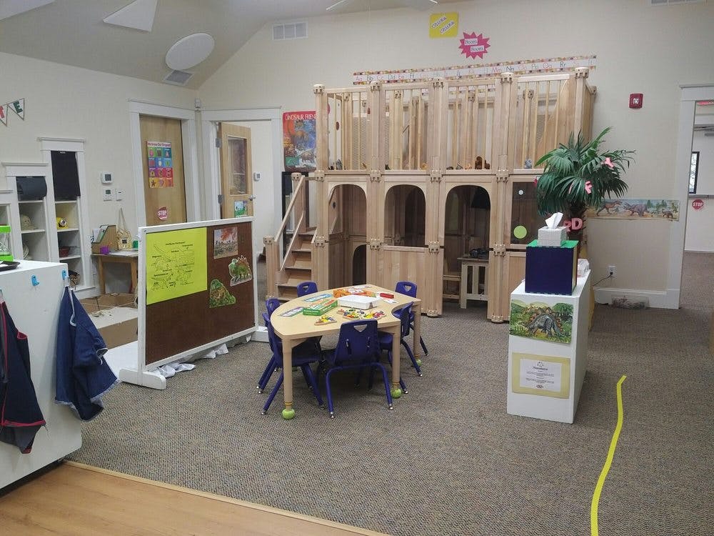 Playroom with a wooden play structure, small table, and chairs