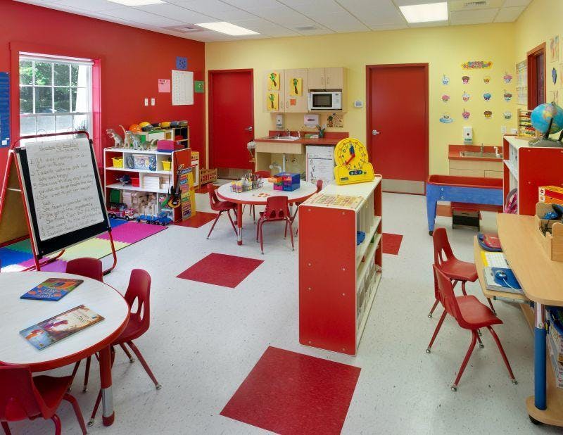 Empty colorful classroom with small tables and chairs