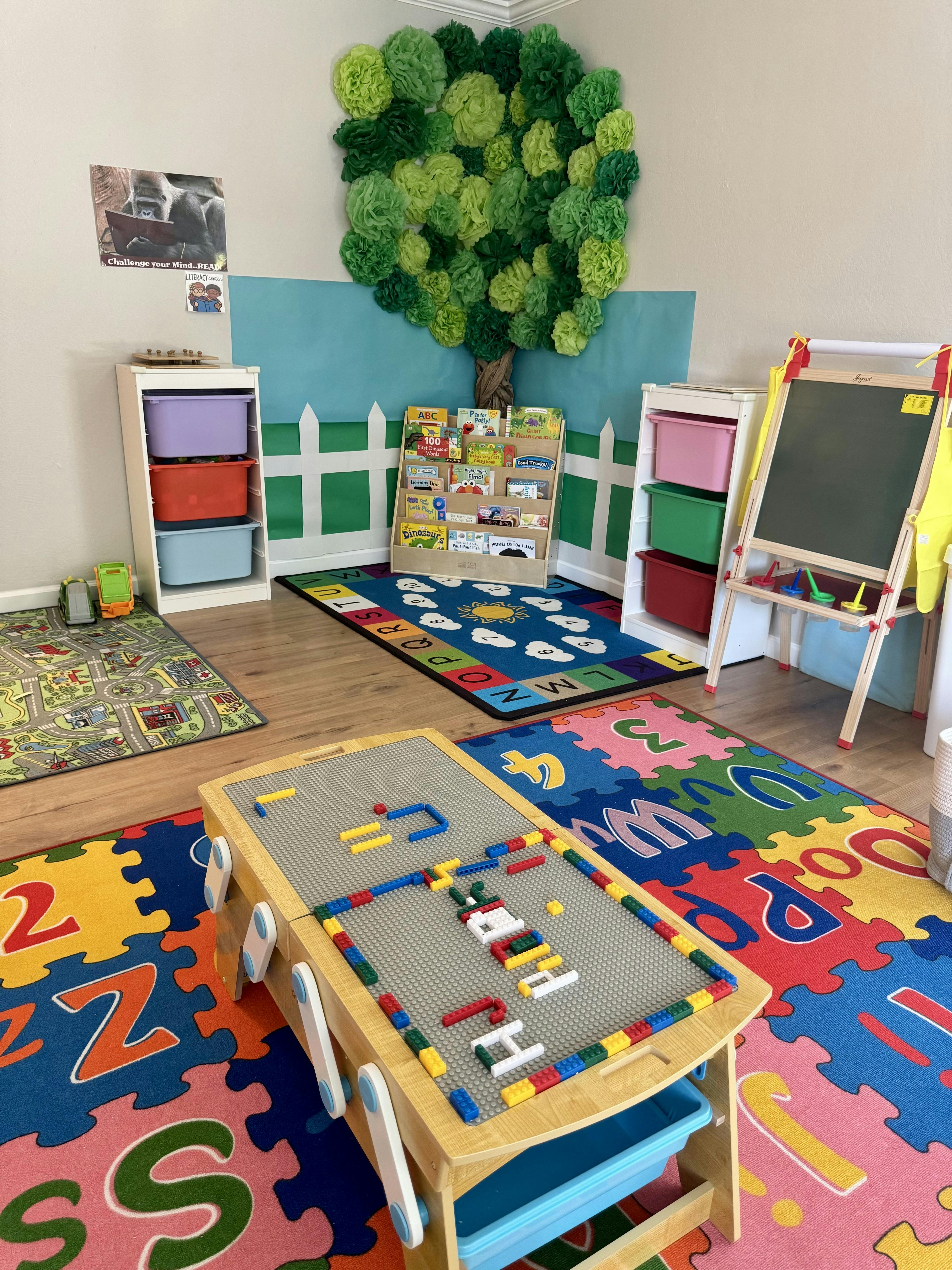 Playroom with colorful rugs, toy storage, and a play table