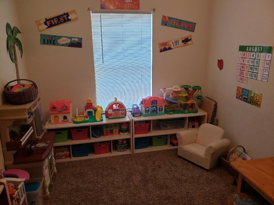 Playroom with shelves of toys, a small chair, and a window