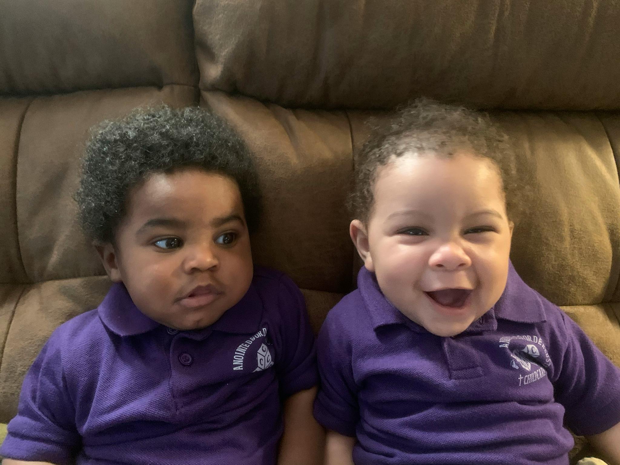 Two children in purple shirts sitting together