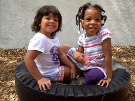 Two children sitting in a tire