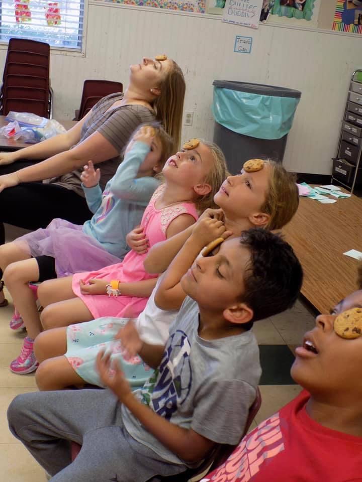 People and children with cookies on their foreheads and faces