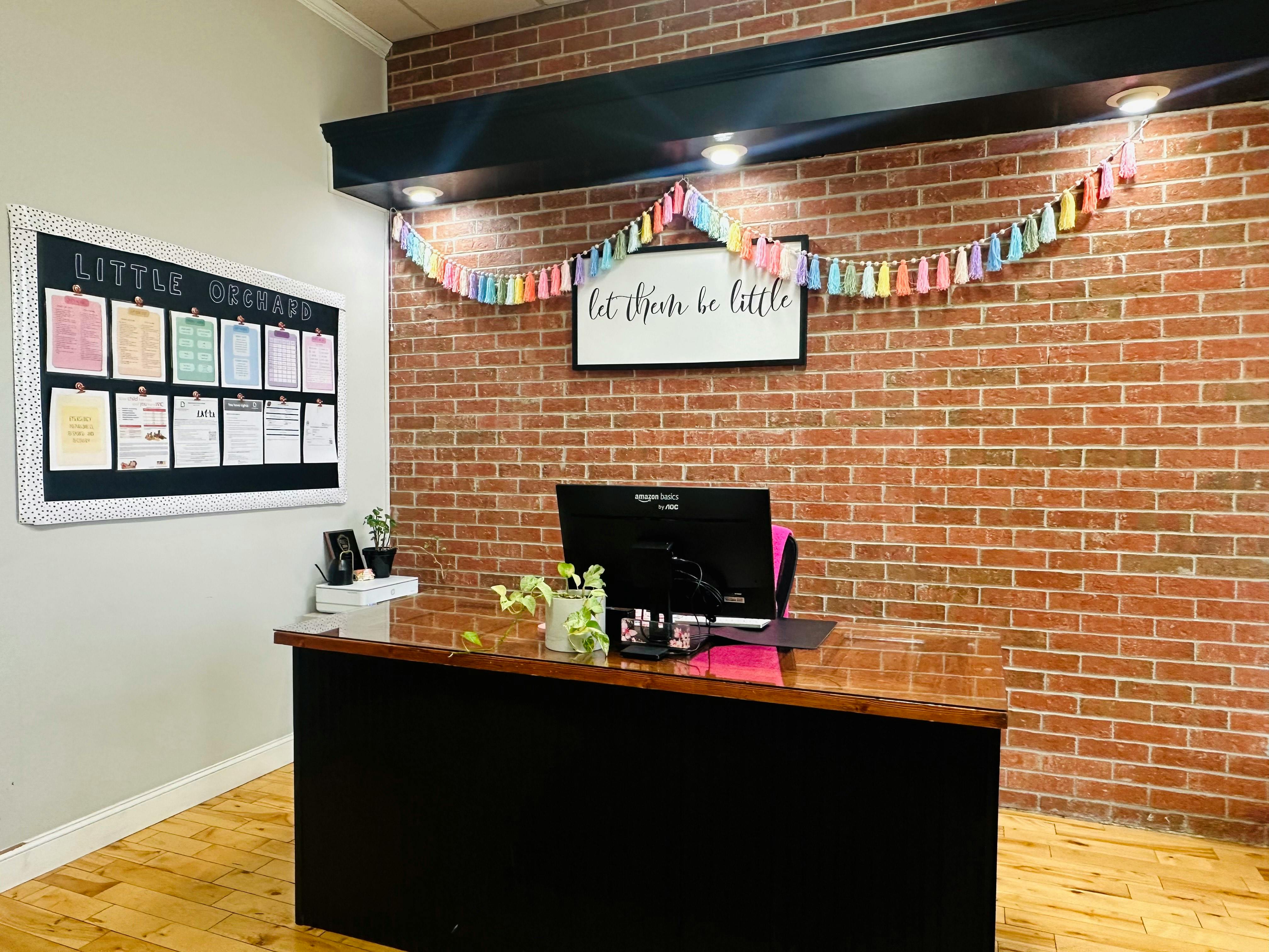 Reception desk with a computer monitor and a bulletin board on the wall