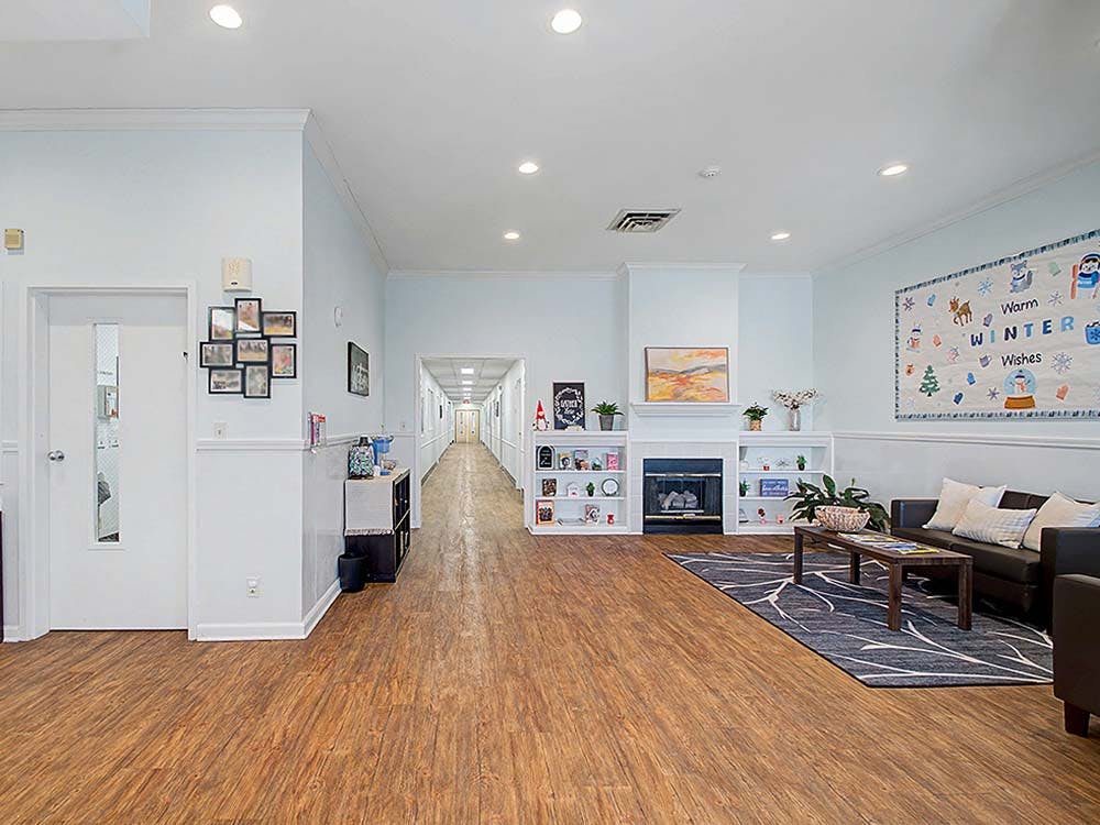 Lobby area with a couch, coffee table, rug, fireplace, and bulletin board