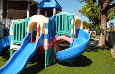 Colorful playground structure with slides on artificial turf