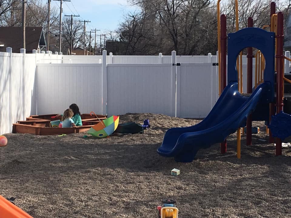 Two children playing in a sandbox on a playground