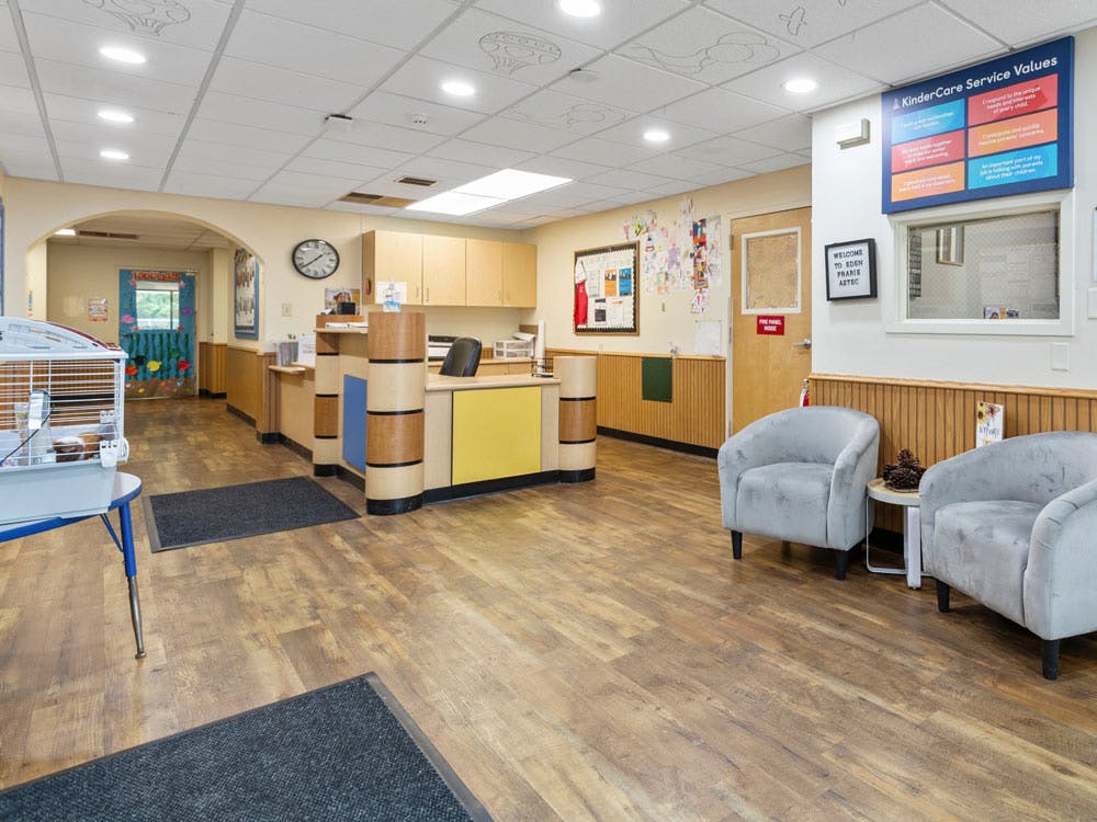 Reception area in a childcare center with a front desk, seating, and guinea pig cage