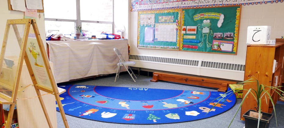 Classroom with a blue semicircular rug and bulletin board