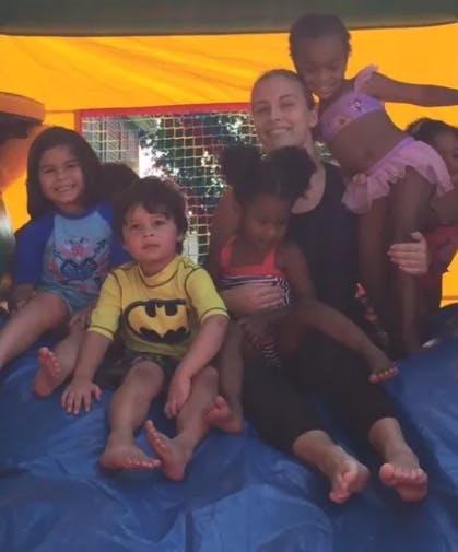 Adult and children sitting together in an inflatable bounce house
