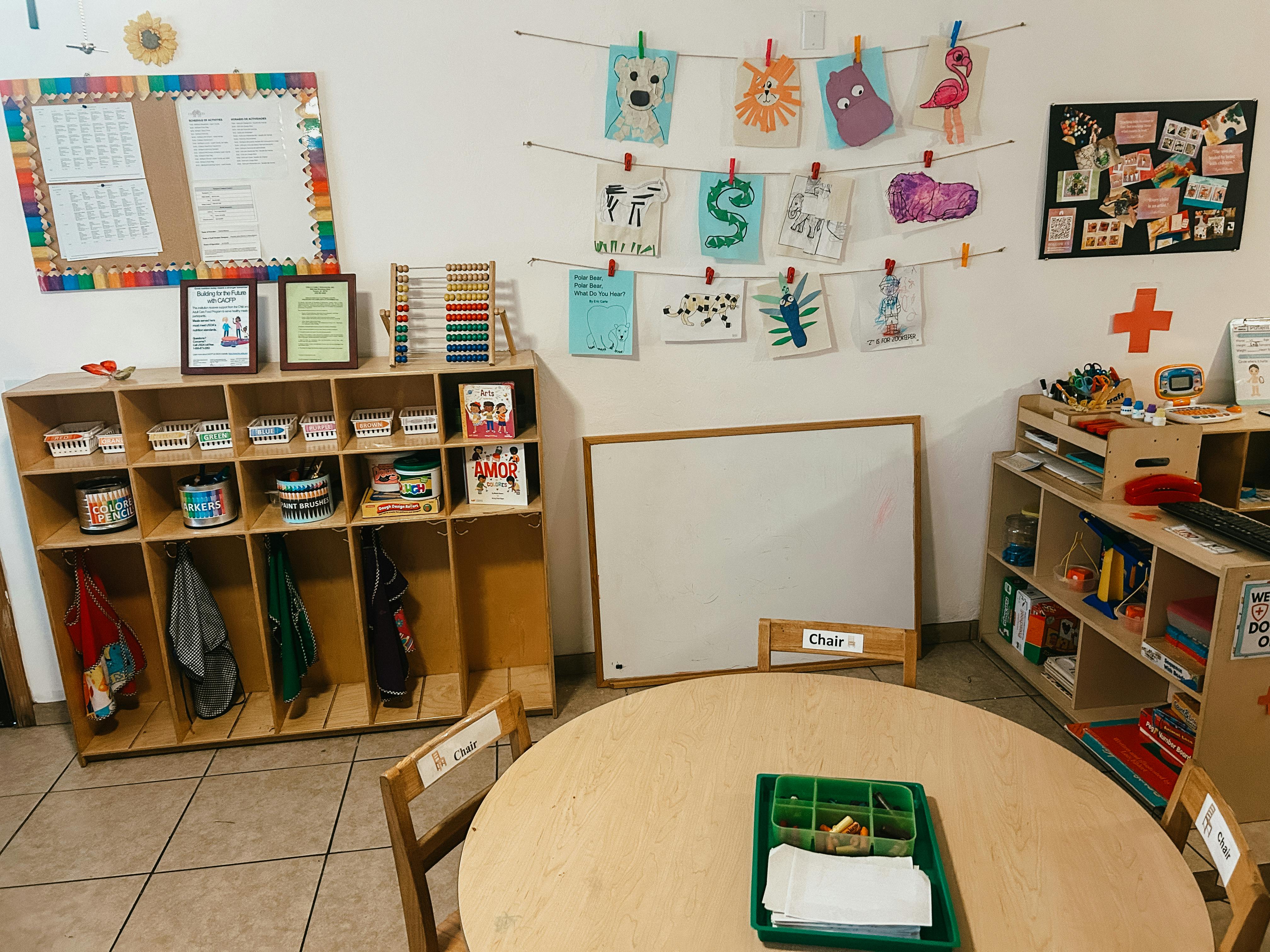Classroom with cubbies, whiteboard, and children's artwork on display