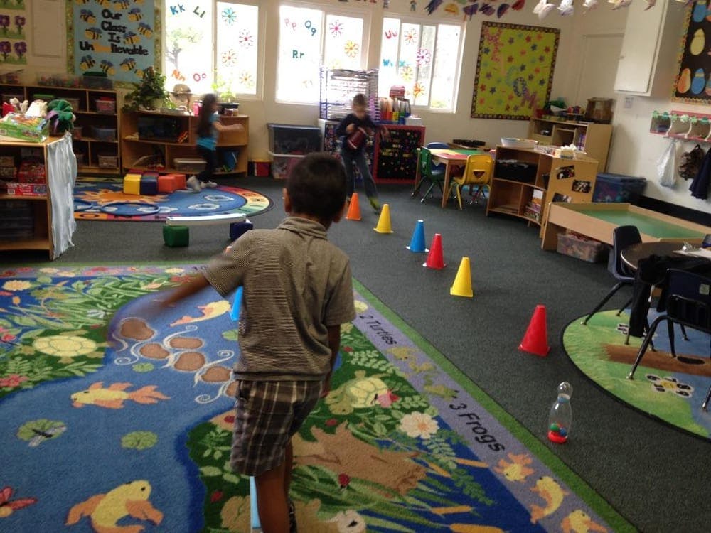 Child in a classroom with colorful cones on the floor
