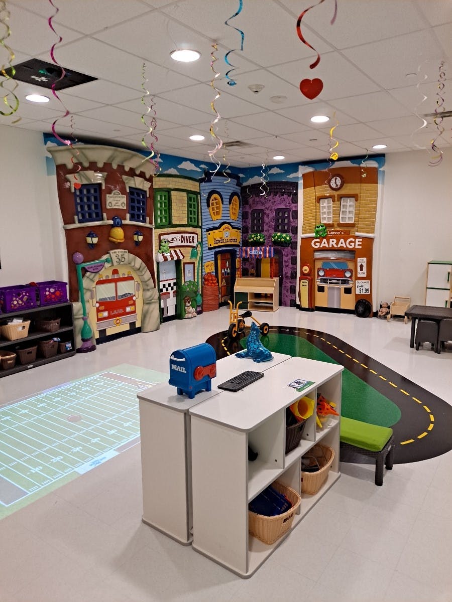 Playroom with building facades, road mat, and toy mailbox