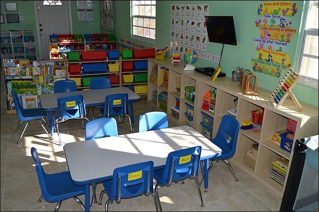 Empty classroom with small tables and blue chairs