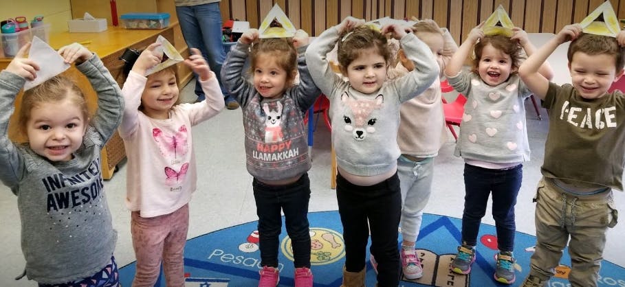 Group of children wearing paper crowns in a classroom