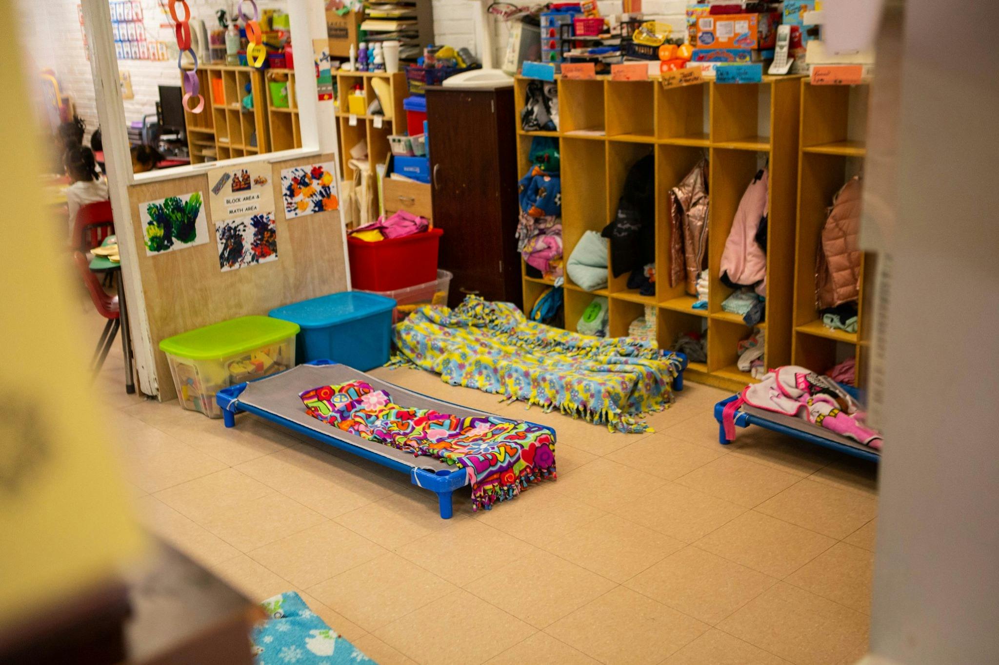 Three cots with blankets in a classroom