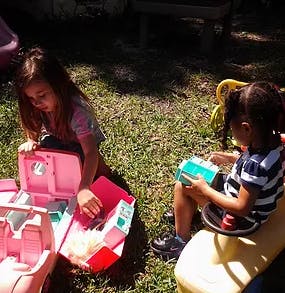 Two children playing with toys outdoors