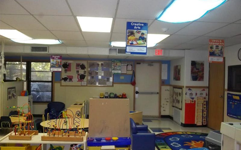 Classroom with play areas, bead mazes, tables, and posters for learning