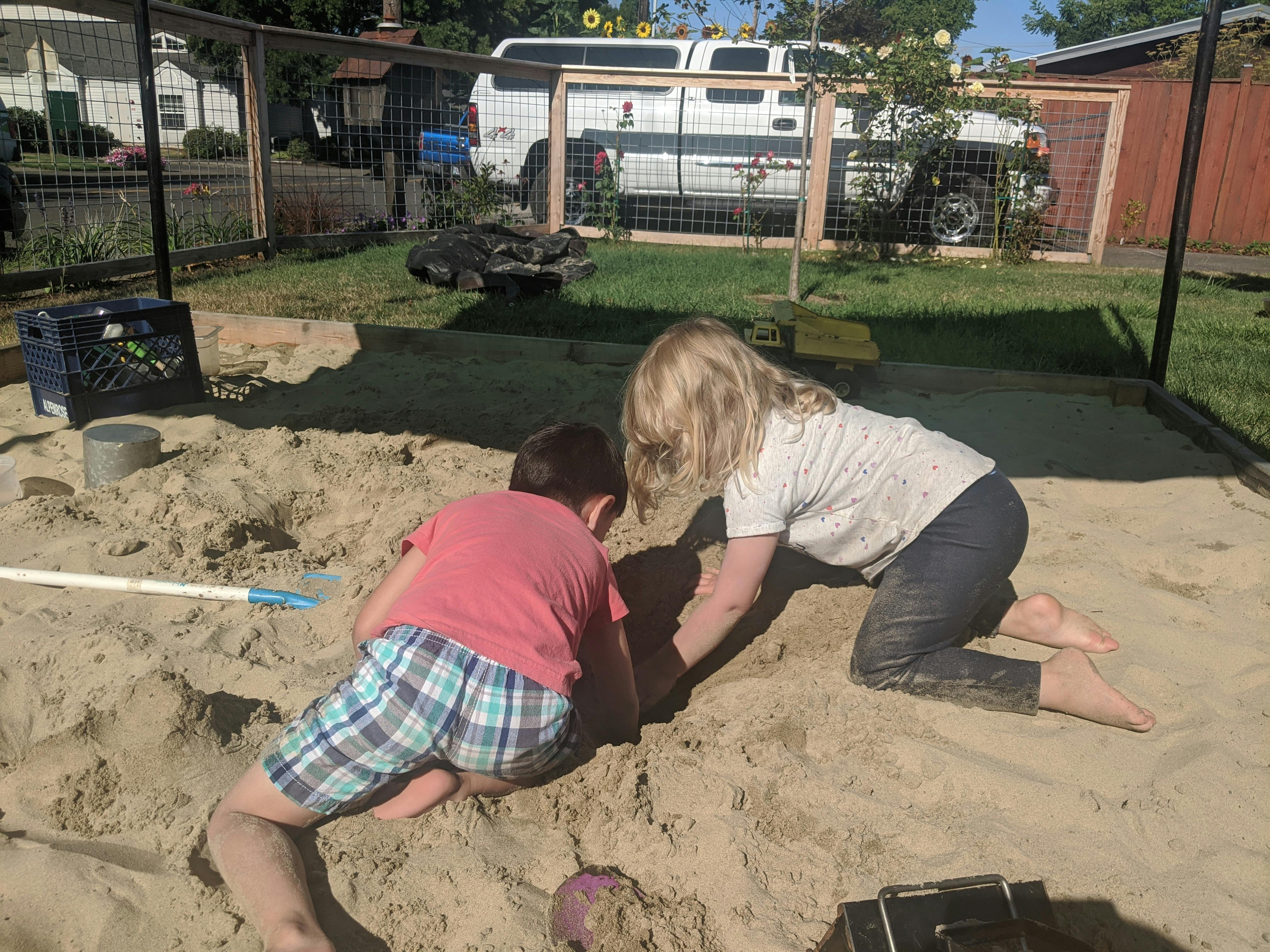 Two children playing in a sandbox