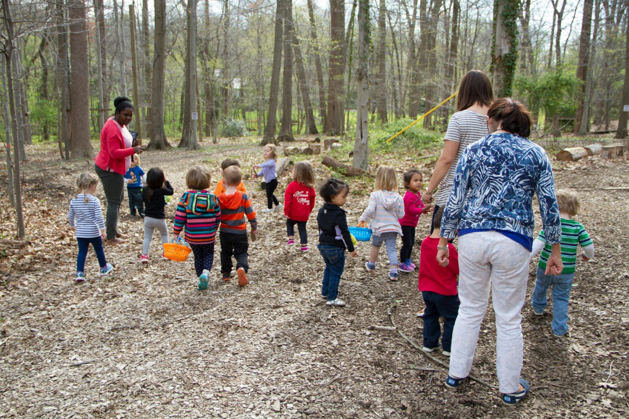 Adults and children walking in a wooded area