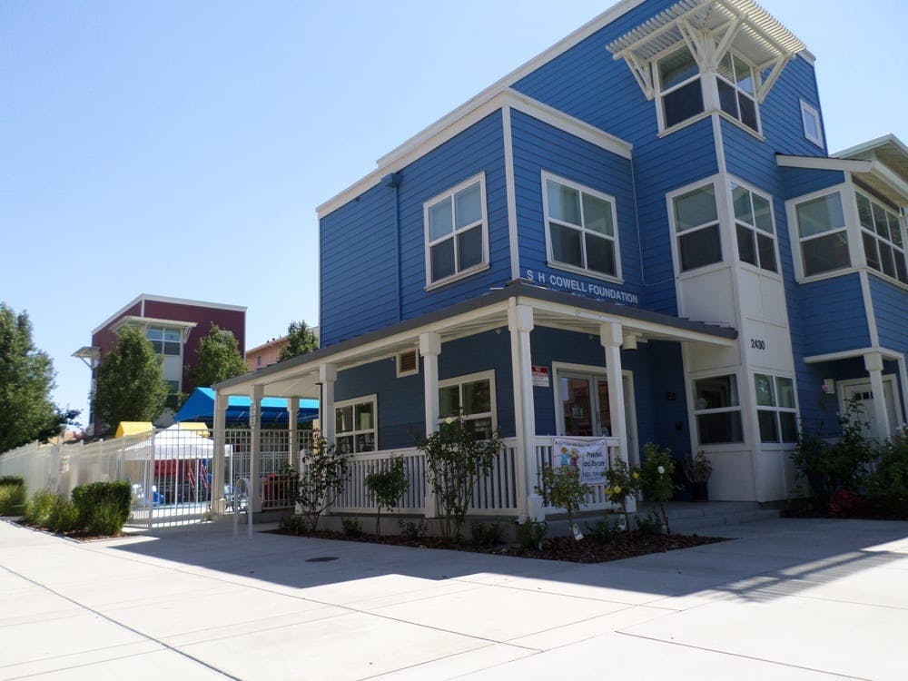 Blue and white building with a porch and white fence