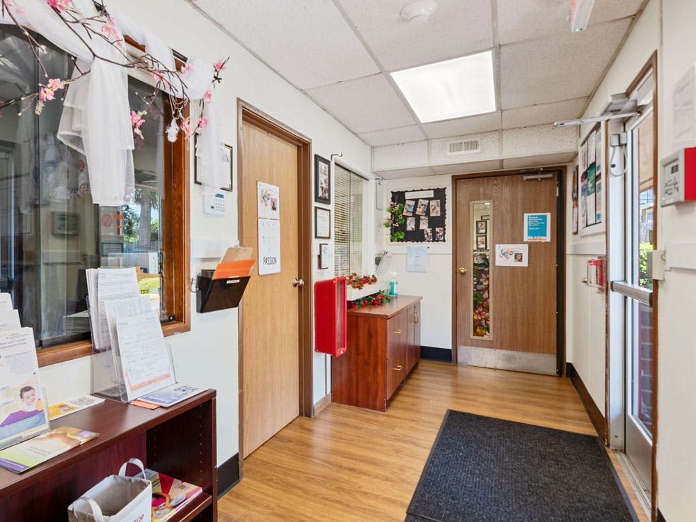 Hallway with wood floors, two closed doors, and informational displays