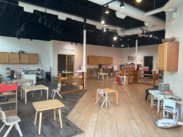 Classroom with small tables and chairs, shelves, and cabinets