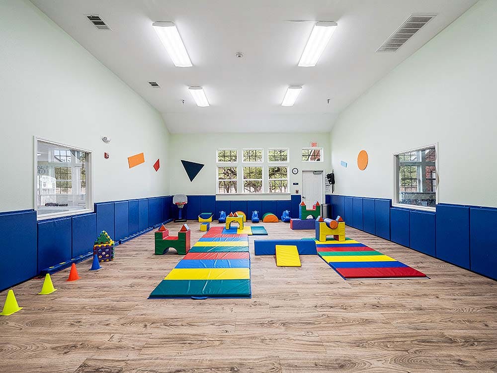 Indoor play area with colorful soft play equipment on a wooden floor