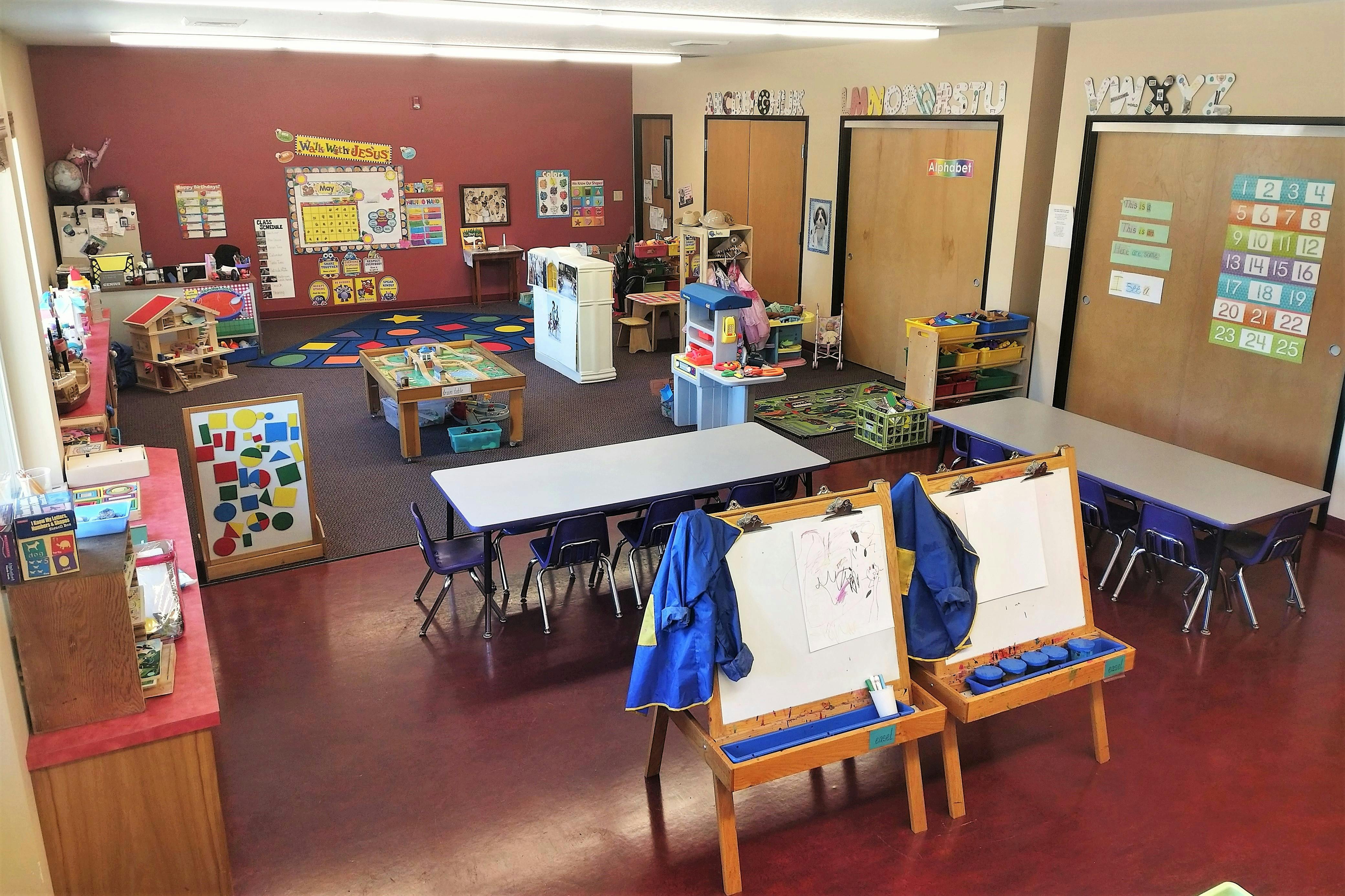 Empty classroom with tables, chairs, and art easels