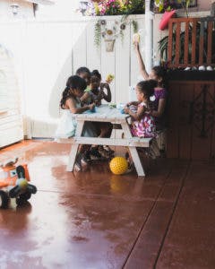 Four children sitting at a small picnic table
