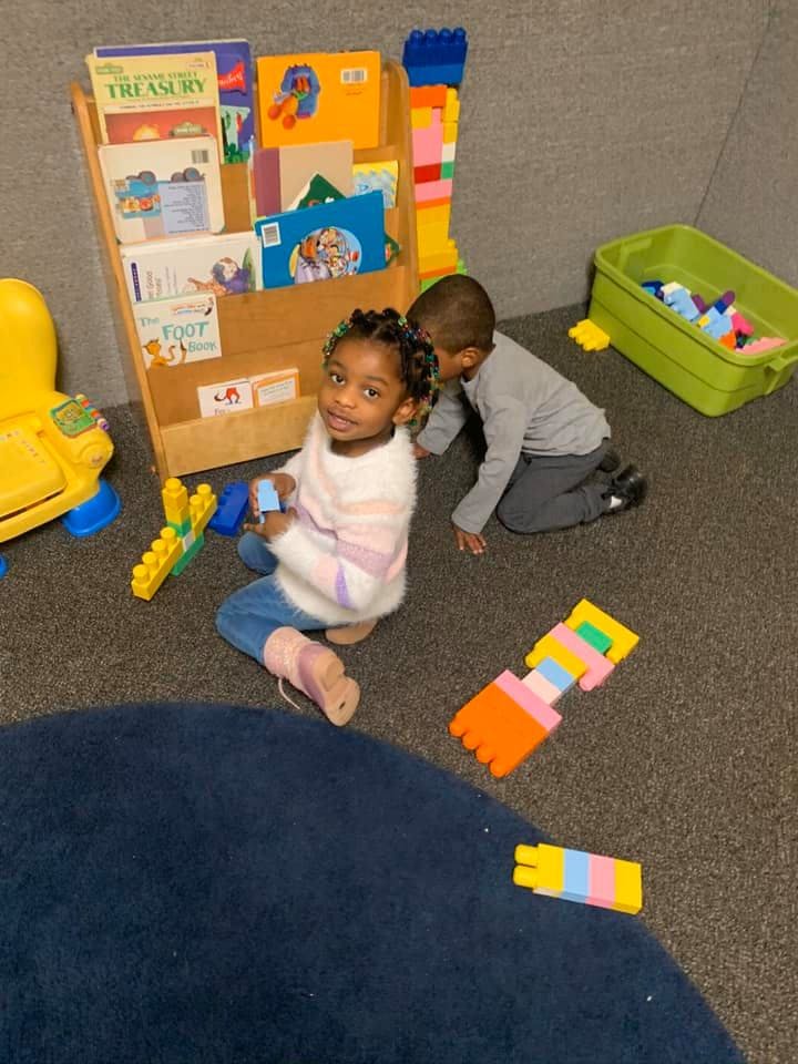 Two children playing with blocks on the floor