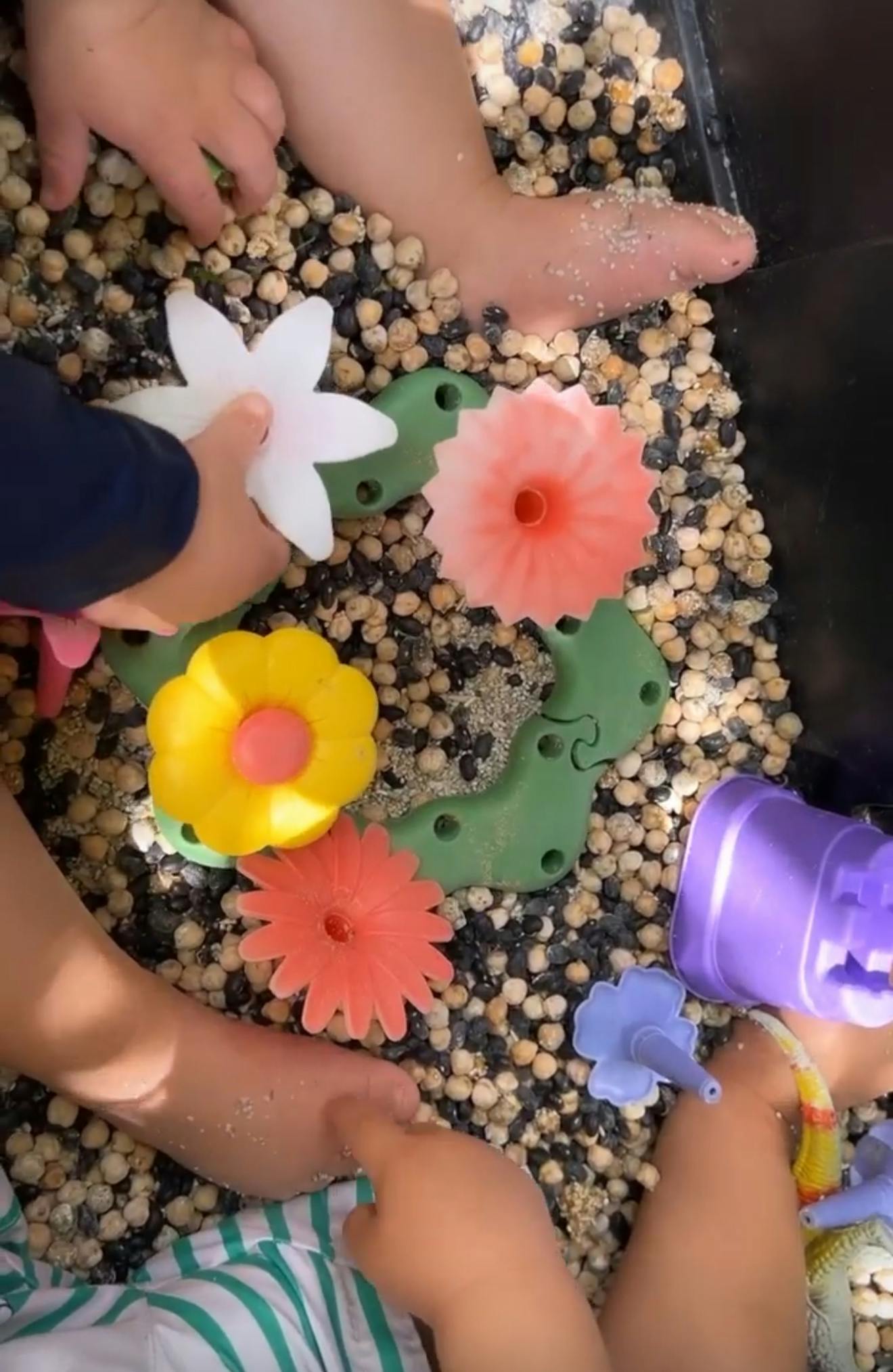 Children playing with flower-shaped toys and chickpeas