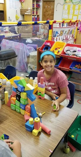 Child sitting at a table with colorful building blocks