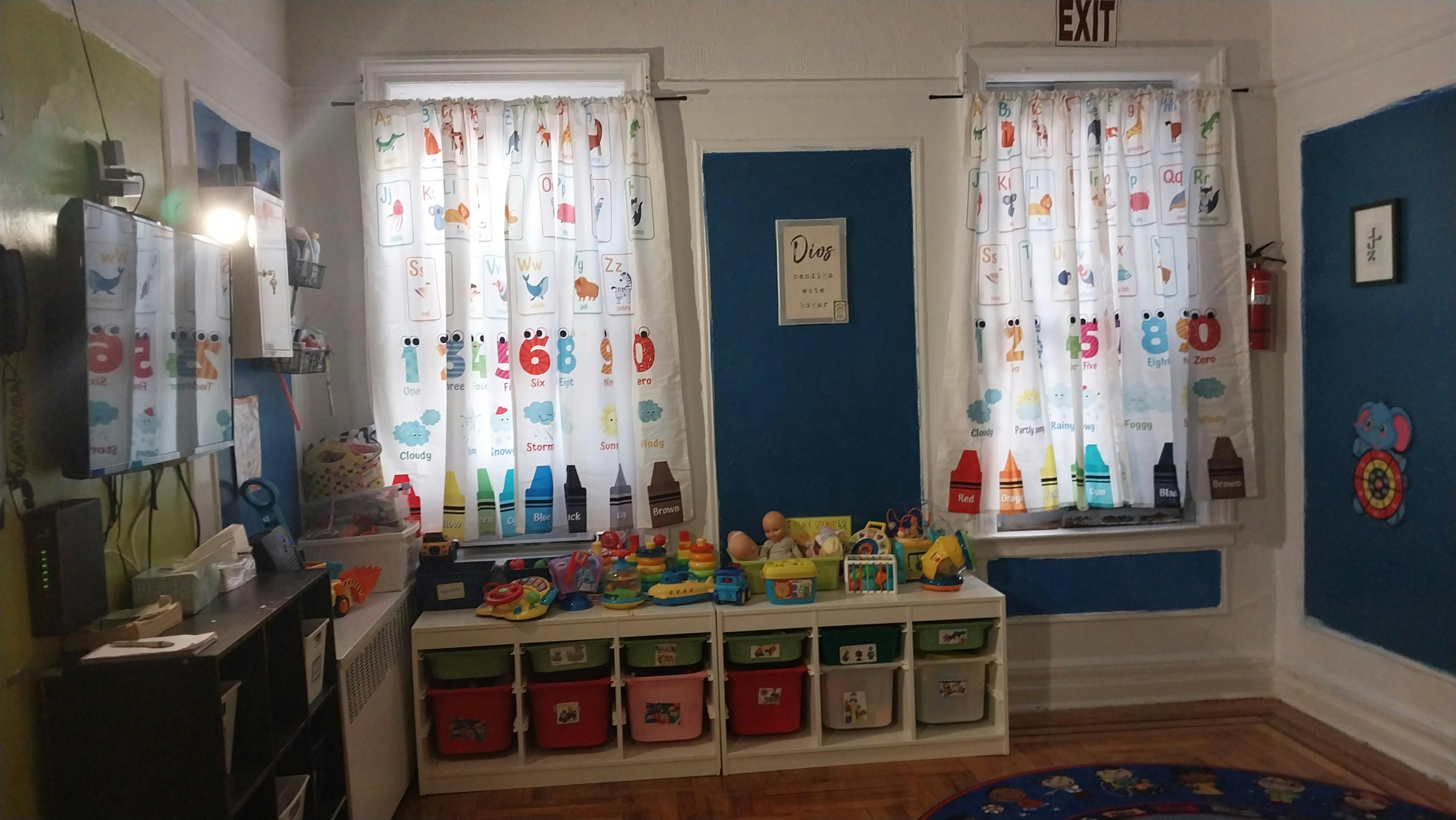 Playroom with two windows, shelves of toys, and a blue door