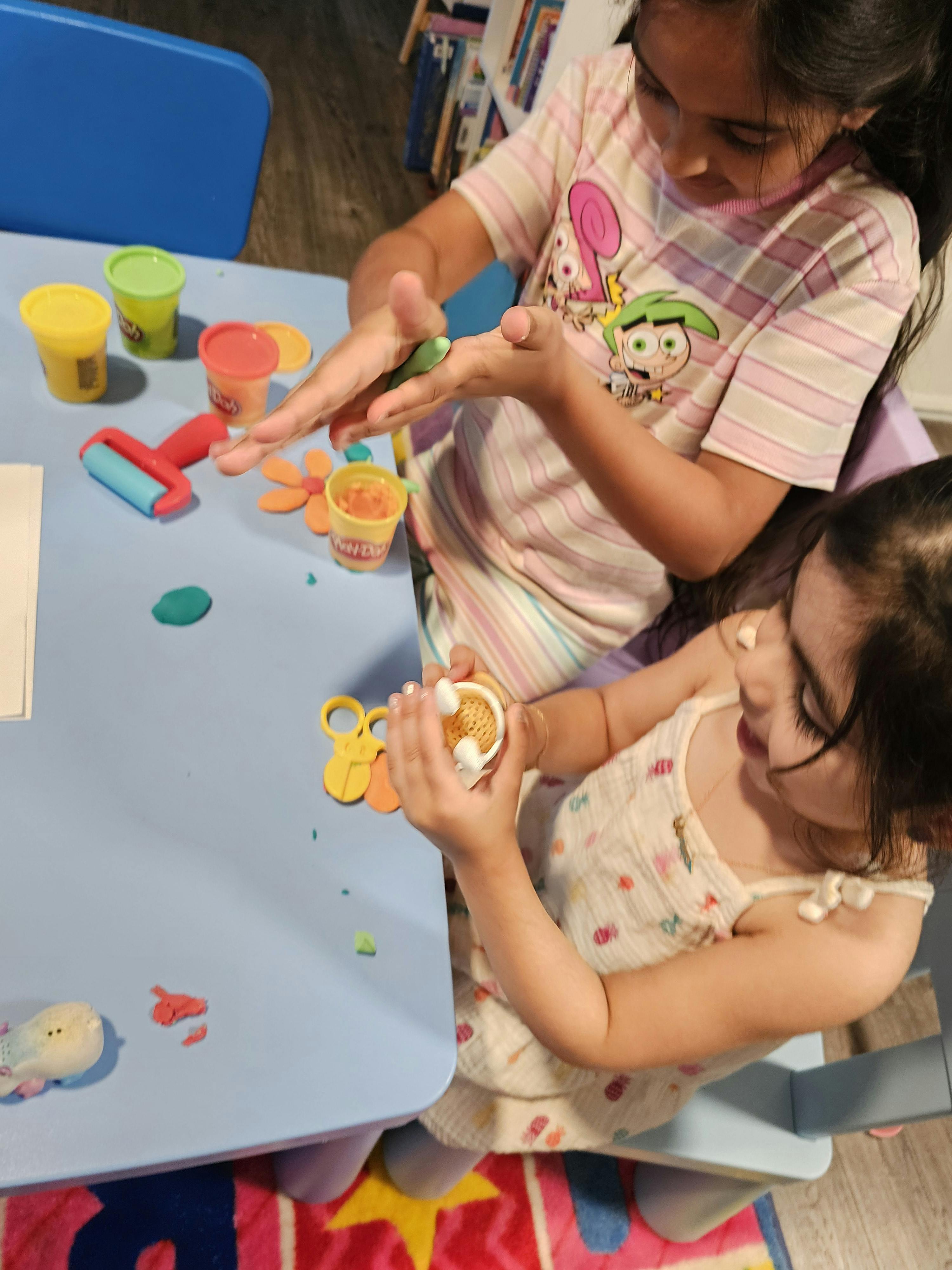 Two children playing with modeling clay at a table